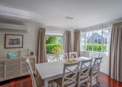Large open-plan indoor dining table configuration seating eight guests at Crab Shack Cottage