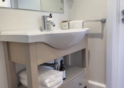 Modern ground floor bathroom with a walk-in glass shower at Crab Shack Cottage.